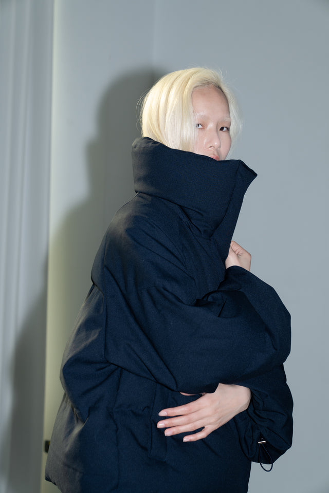 Dark blue quilted down jacket with a large lapel.